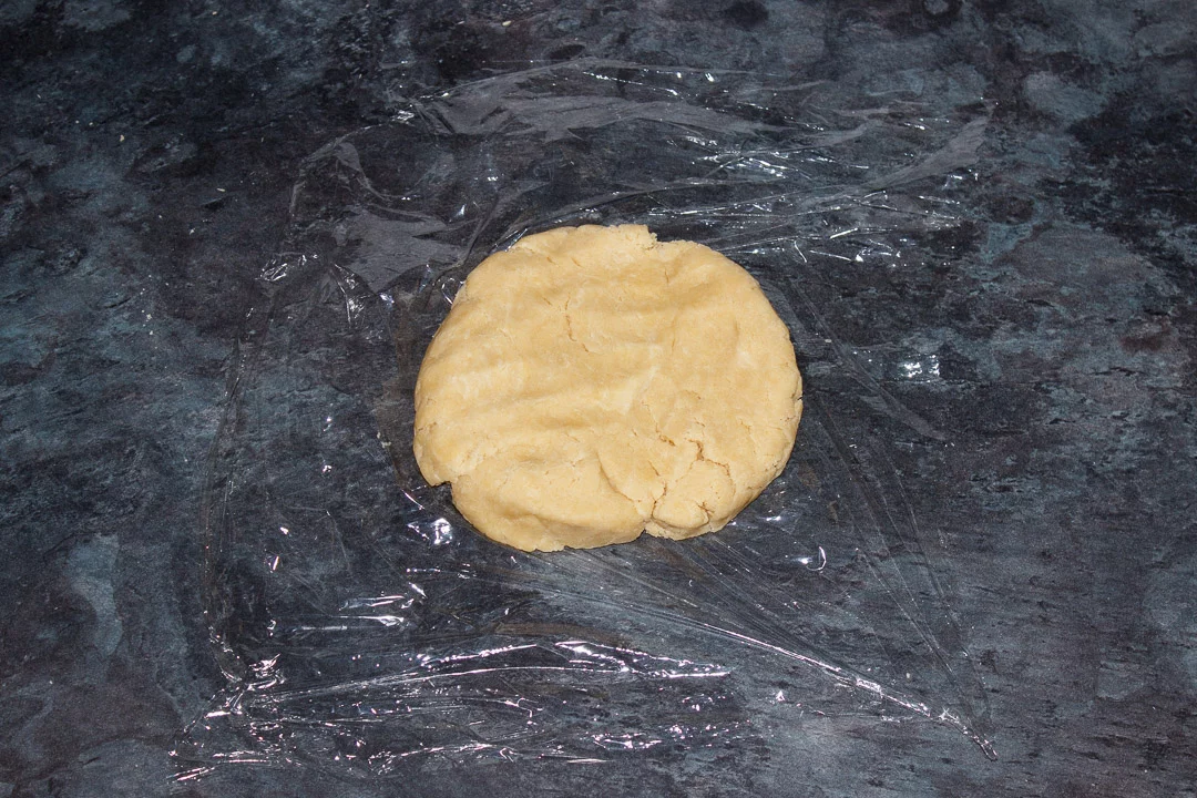 Shortcrust pastry dough flattened on a piece of cling film
