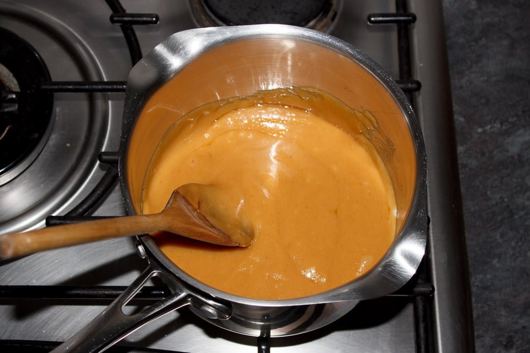 Millionaire deep golden caramel in a medium sized saucepan with a wooden spoon