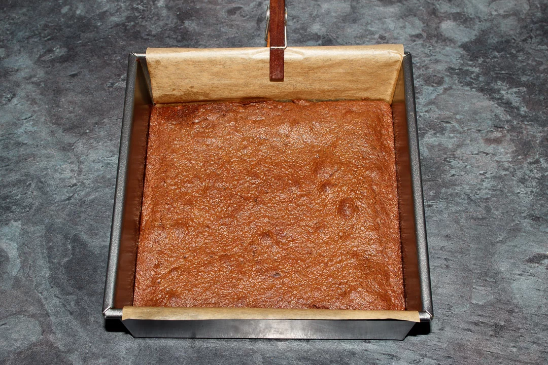 Cooked brownie in a lined square baking tin