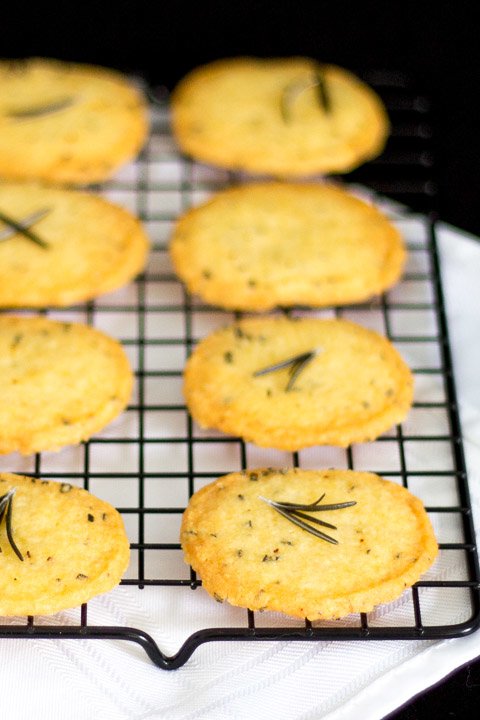 Spicy rosemary thins on a cooling rack topped with fresh rosemary