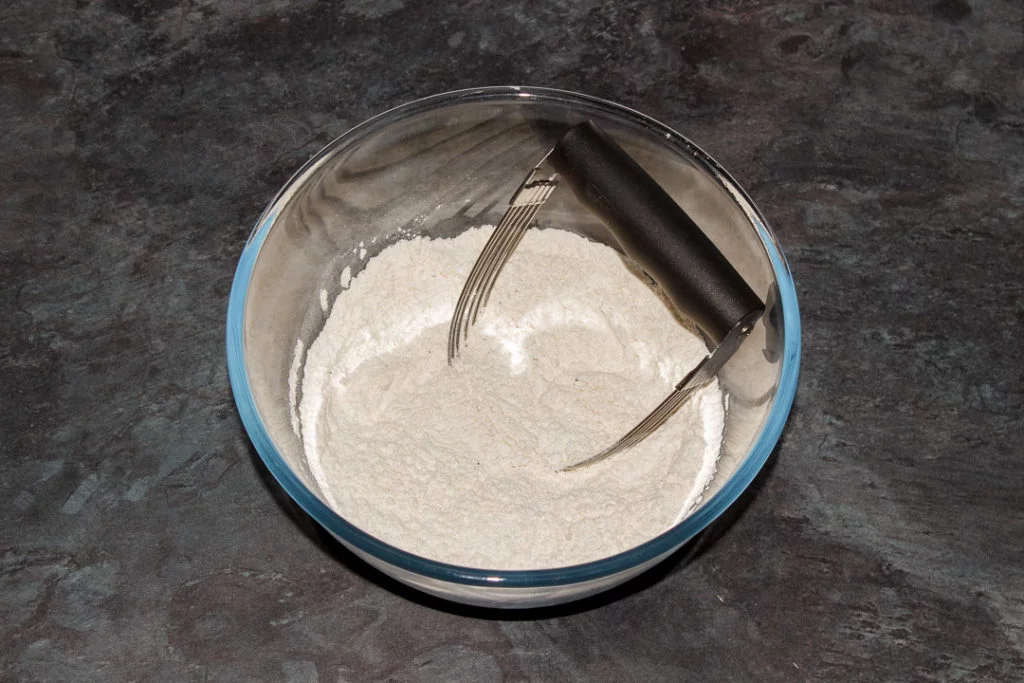Flour, baking powder and seasonings in a large mixing bowl with a pastry blender.