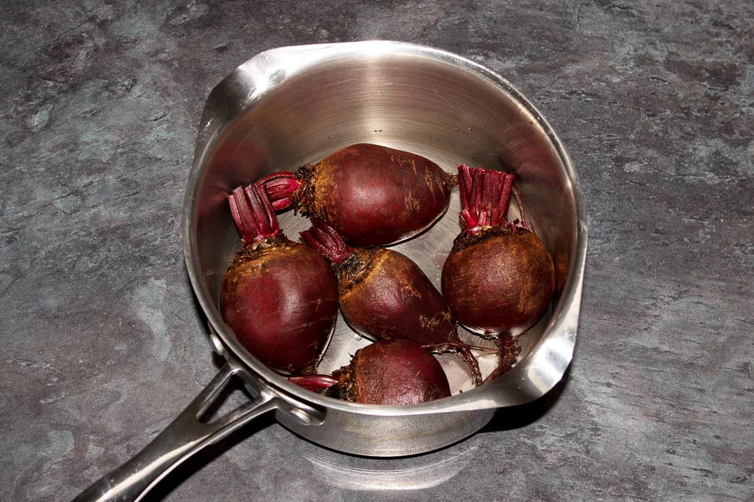 Washed whole beetroot with the stems trimmed in a large saucepan