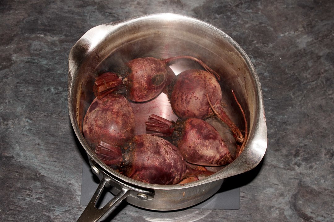 Whole cooked beetroot in a large saucepan