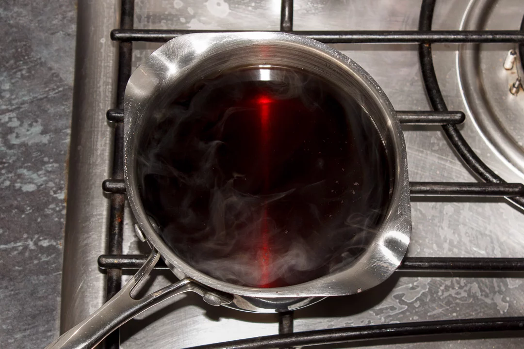 Vinegar and sugar being heated gently in a small pan over a low heat