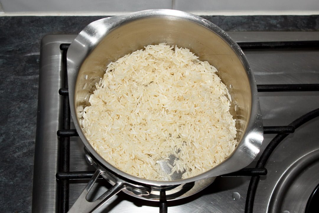 uncooked rice in a saucepan that's been fried in butter
