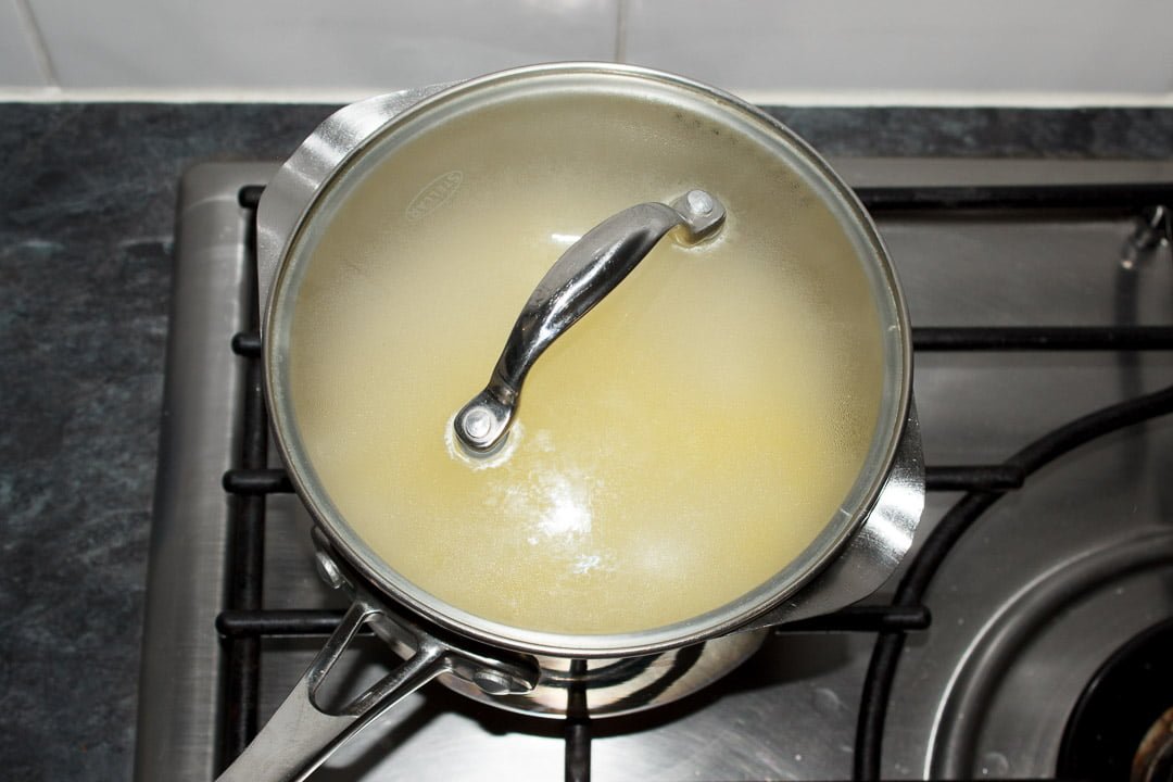 Rice cooking in a saucepan with a lid on