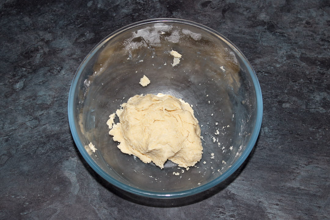 A ball of shortcrust pastry in a glass bwl