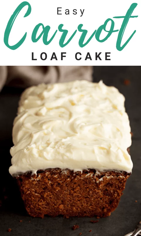 Carrot loaf cake topped with cream cheese frosting on a worktop with a cloth in the background