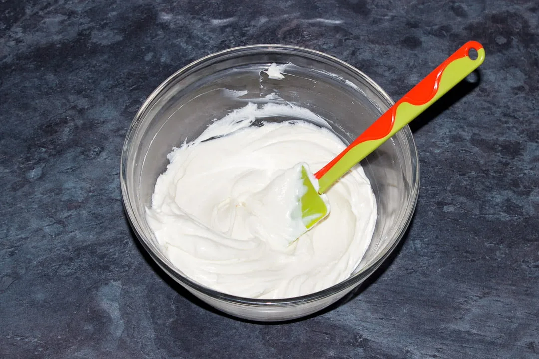 Softened cream cheese and caster sugar beaten together in a glass bowl with a rubber spatula