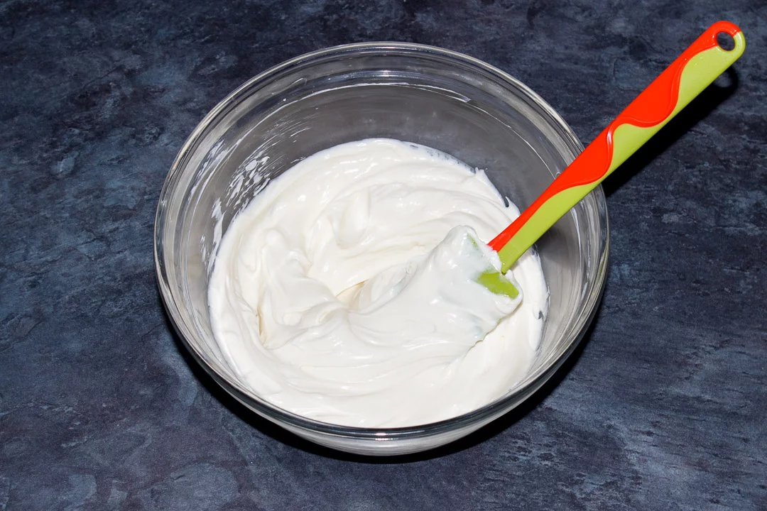 Softened cream cheese, caster sugar and vanilla extract beaten together in a glass bowl with a rubber spatula