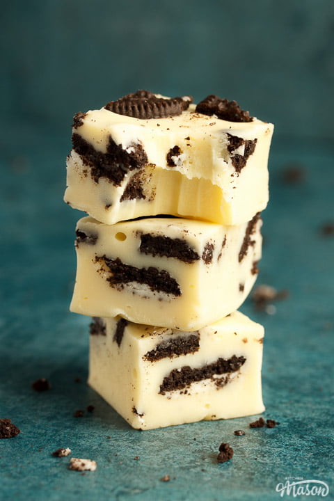 Oreo fudge in a stack of 3, the top piece has a bite out of it