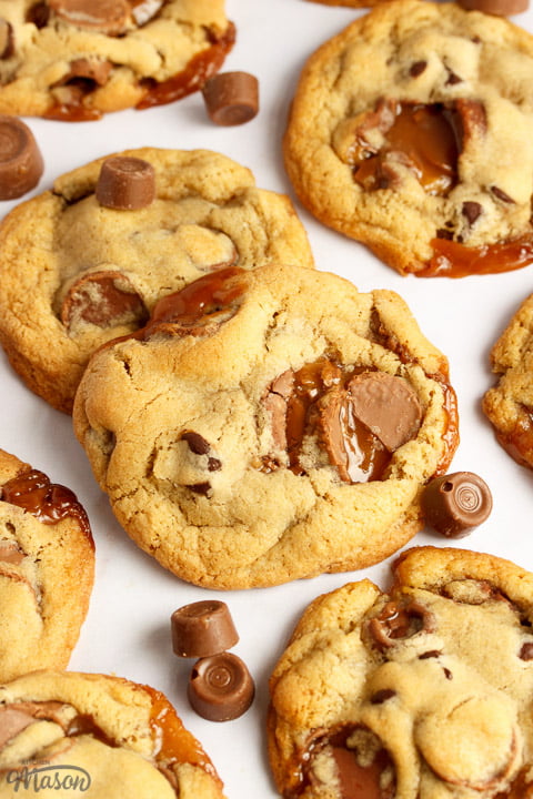 Rolo cookies on a white marble worktop with large and small Rolos scattered around them