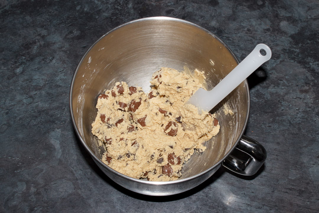 Rolo cookie dough in the bowl of an electric stand mixer with a spatula