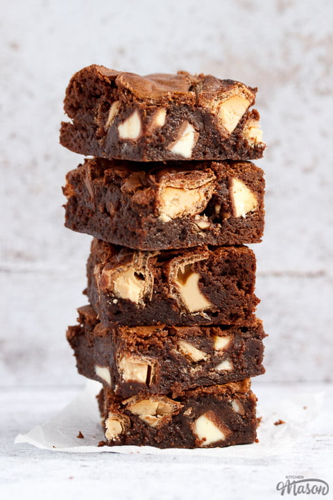 Kinder Bueno Brownies in a stack on a piece of crumpled white baking paper.