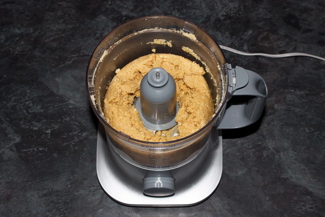Crushed biscuit crumbs mixed with melted butter in a food processor
