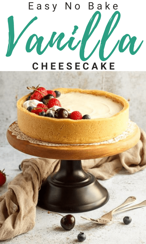 No bake vanilla cheesecake on a cake stand topped with mixed berries, surrounded by a light brown napkin and two forks