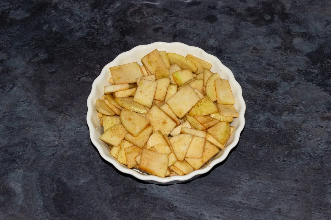 Sliced marinated apples in a dish