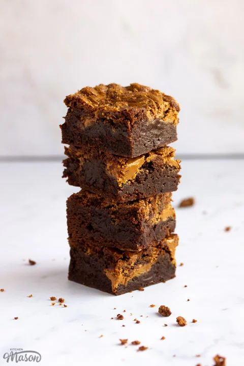 Biscoff brownies in a stack of 4 bars on a white work surface