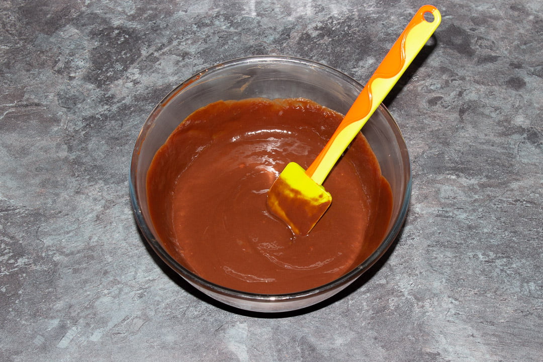 Melted dark chocolate, butter and eggs beaten together in a glass bowl with a rubber spatula