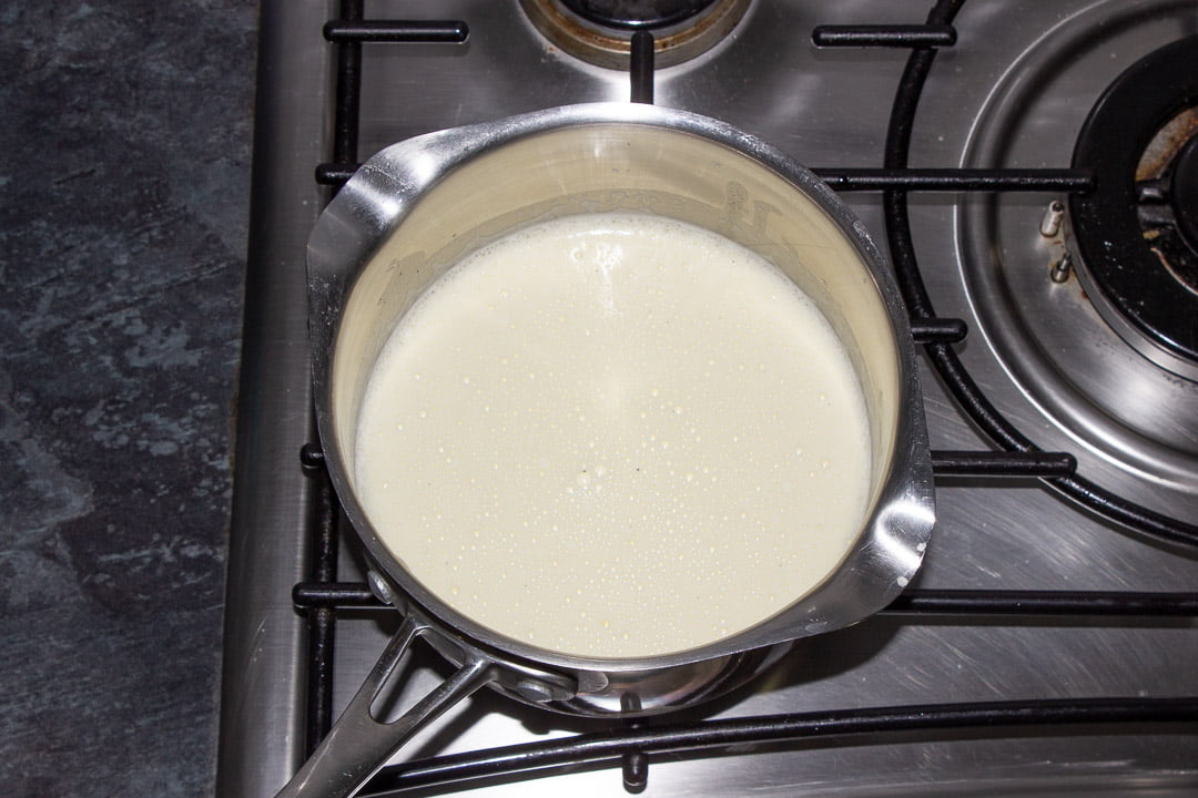 A vanilla custard base in a metal saucepan on a stove