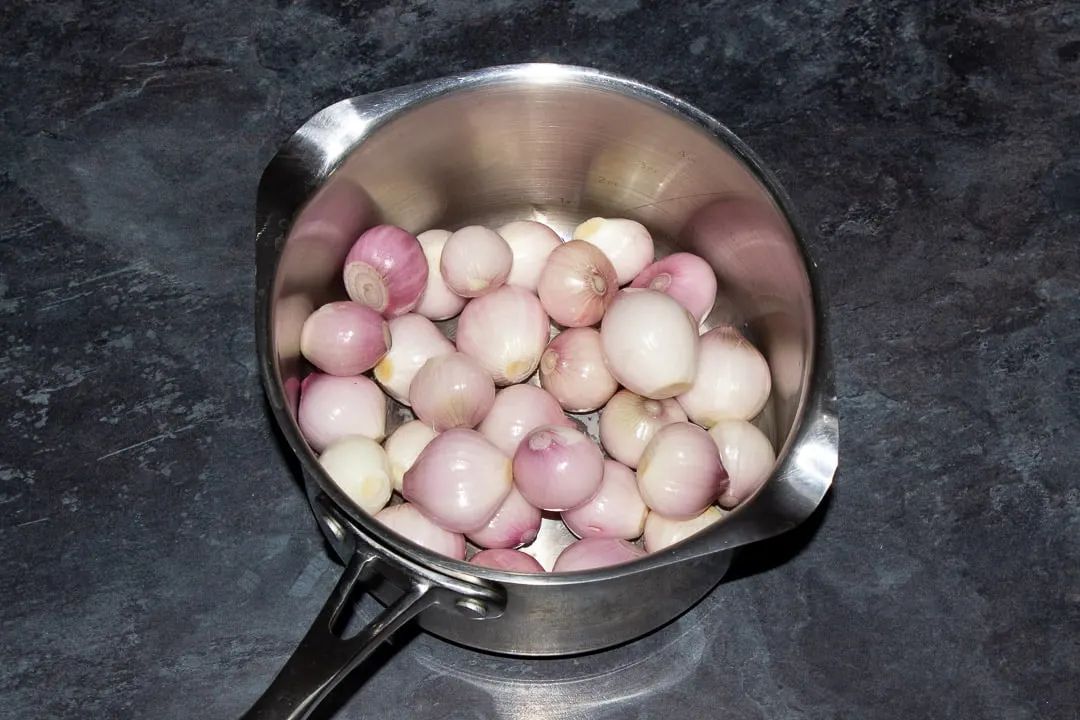 Peeled and trimmed baby shallots in a large saucepan