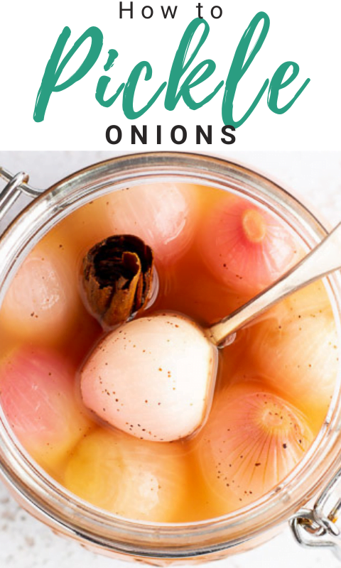 A jar of pickled onions with a fork inside on a white mottled background