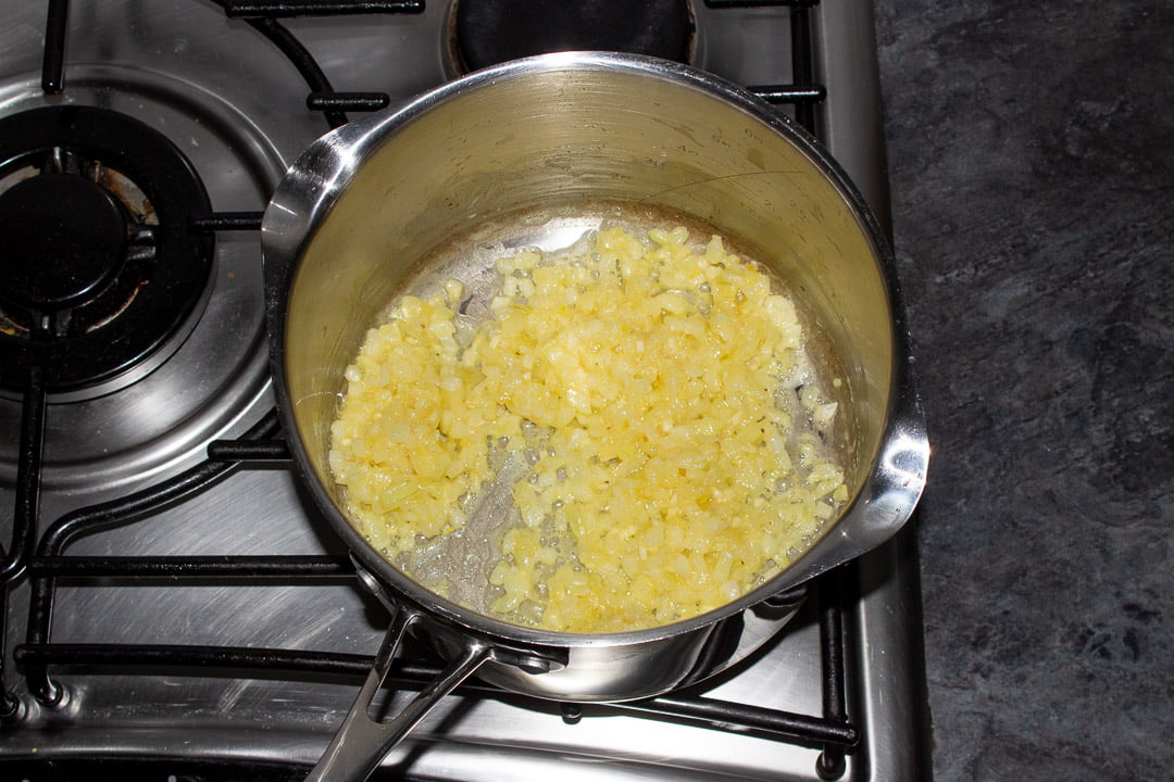 Onions, garlic and flour frying in butter in a saucepan on a hob