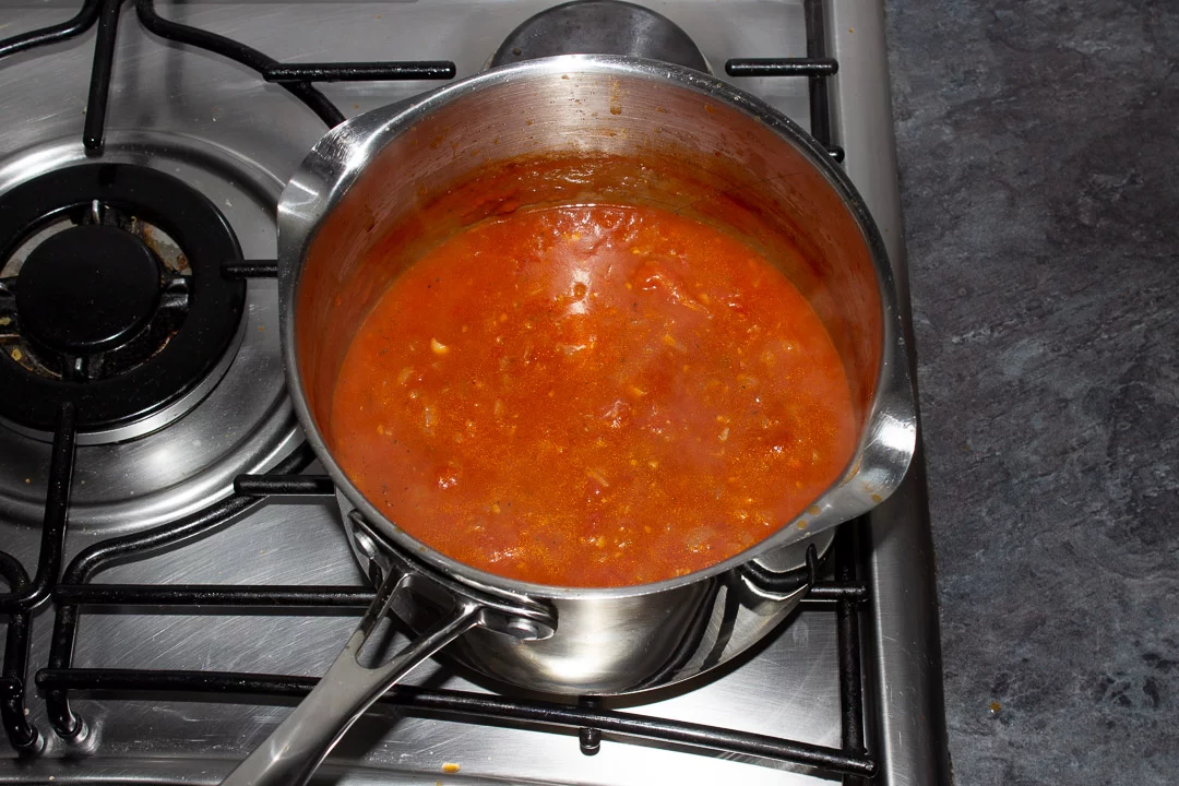 Reduced tomato soup in a saucepan on a hob