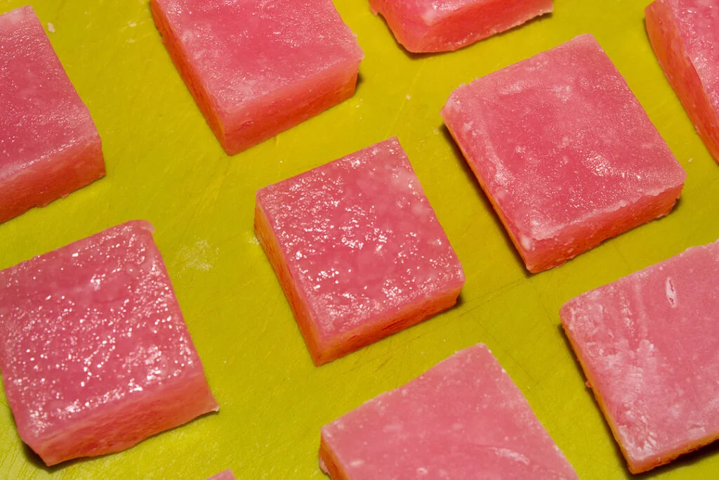 Sweating Turkish delight cut into cubes resting on a green chopping board