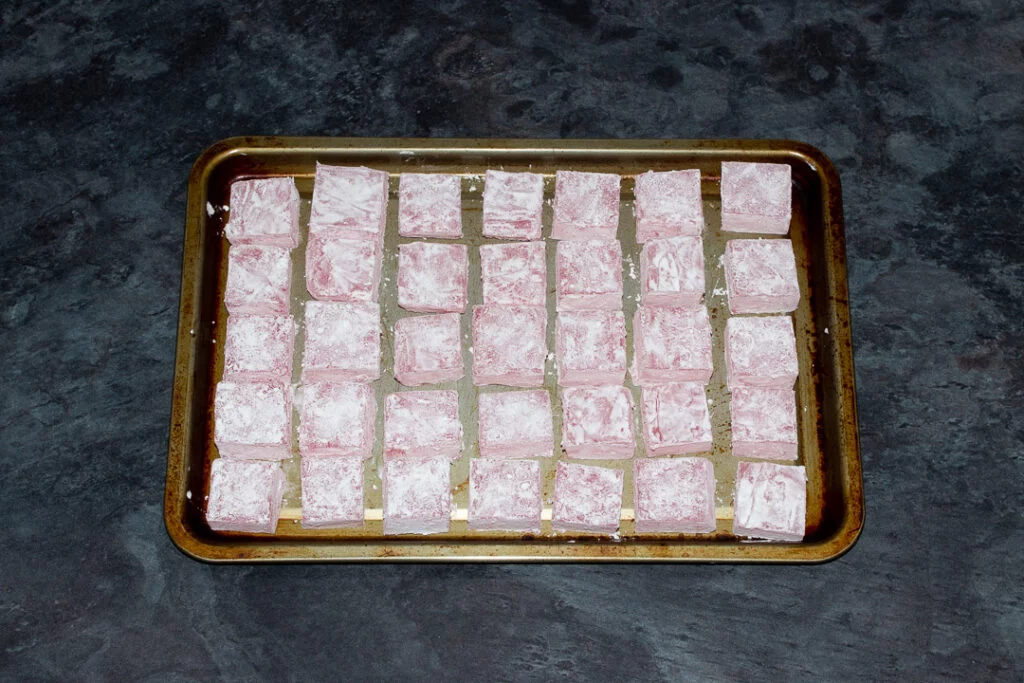 Turkish delight cubes coated in cornflour on a baking tray