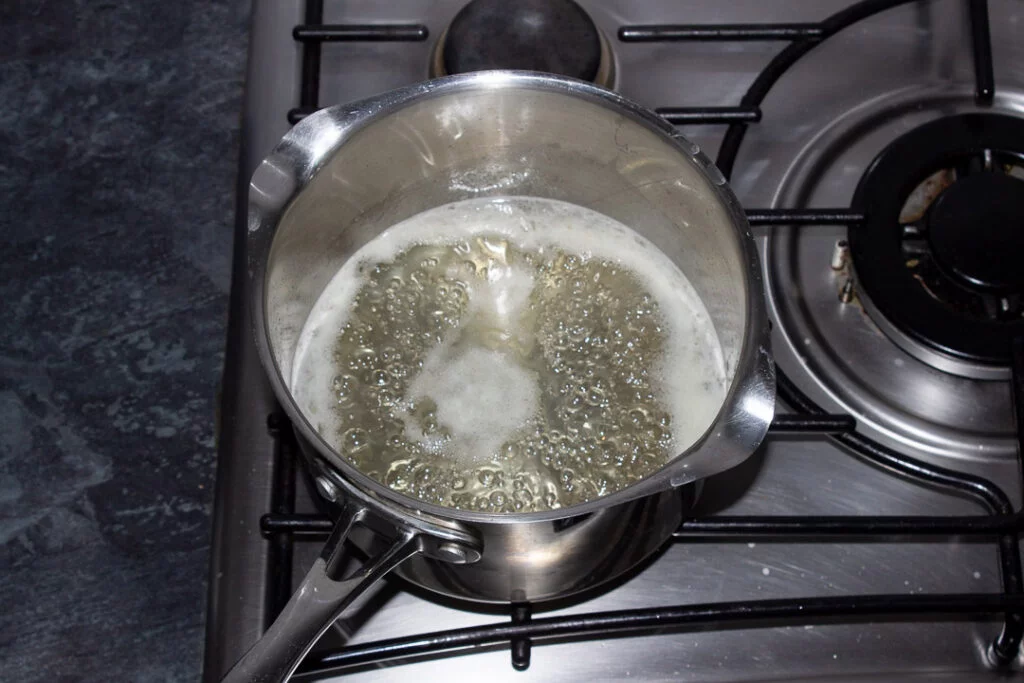 Sugar, lemon juice and water simmering in a saucepan on the hob