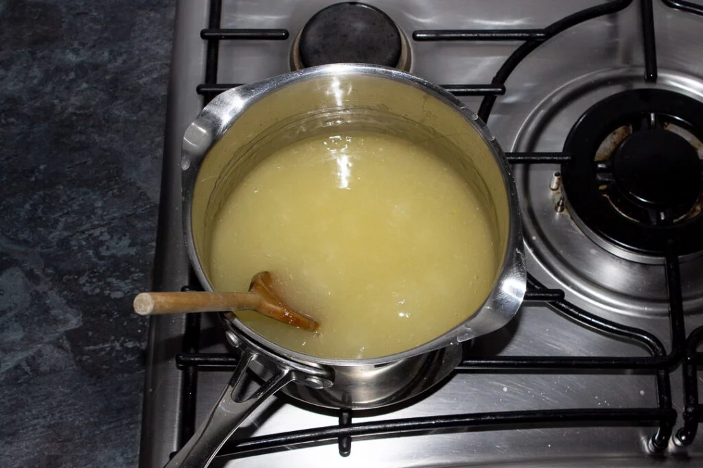 Sugar, lemon juice, water, cornflour and gelatine thickening in a saucepan on a hob