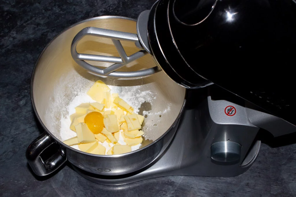 Butter, icing sugar, egg yolk, vanilla and salt in an electric stand mixer ready for creaming