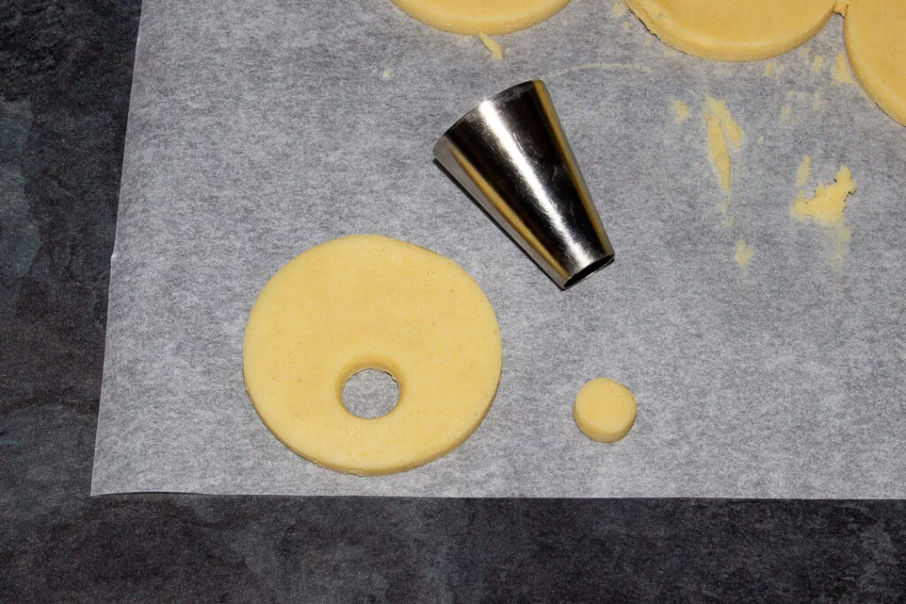 Cookie dough cut into a circle with a small hole cut out from the middle using the end of a round piping nozzle