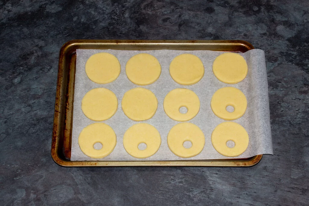 Cookies cut out and laid on a lined baking sheet ready to be chilled