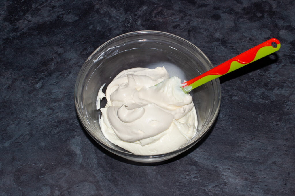 Baileys whipped cream being folded into whipped cream cheese