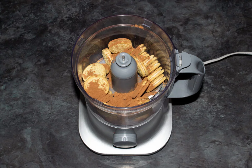 Golden Oreos and cocoa powder in a food processor