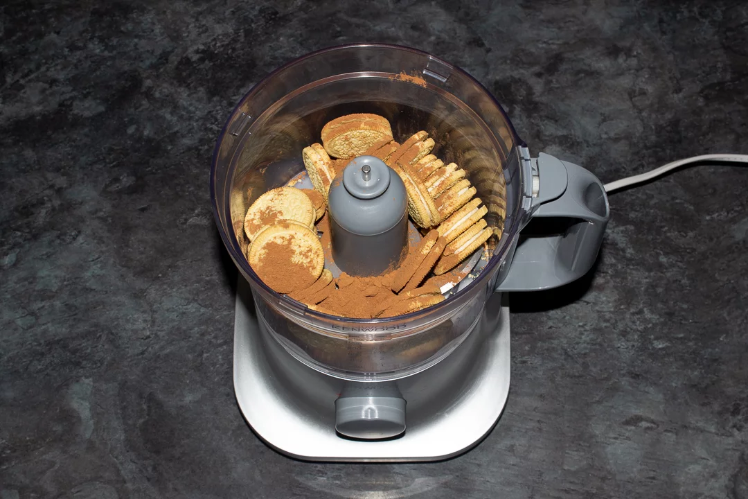 Golden Oreos and cocoa powder in a food processor ready for blending
