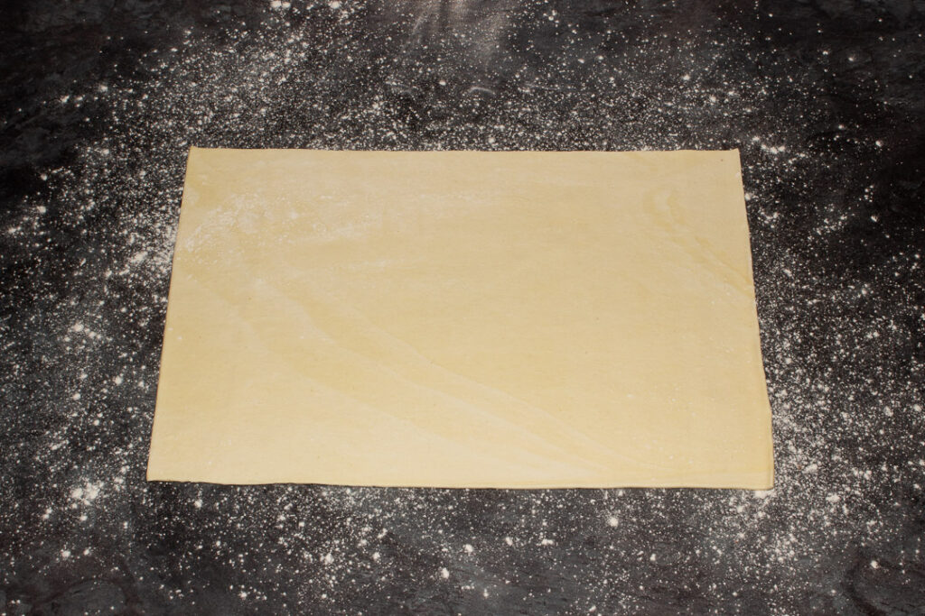 A sheet of ready rolled puff pastry on a lightly floured work surface