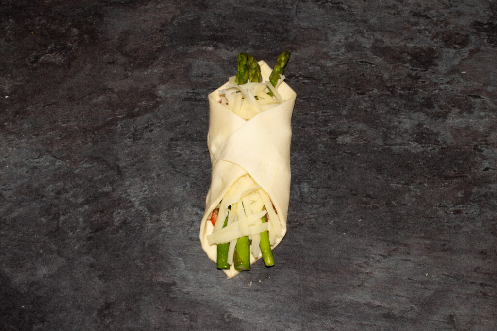 An asparagus puff pastry parcel folded and ready to be egg washed.