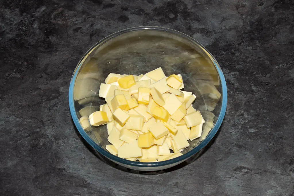 butter and white chocolate in a glass bowl on a kitchen worktop