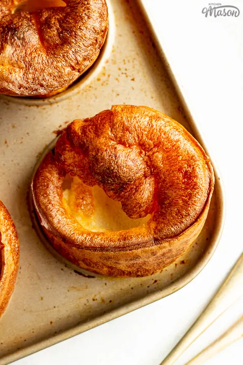 Yorkshire puddings in a pan with a fork