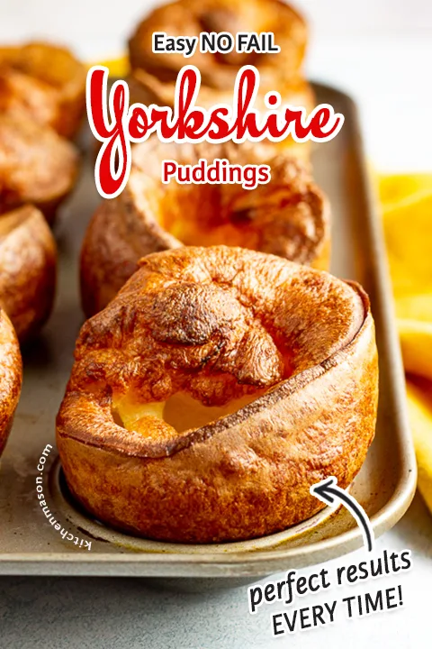 Yorkshire puddings in a Yorkshire pudding pan with a mustard yellow napkin in the background.
