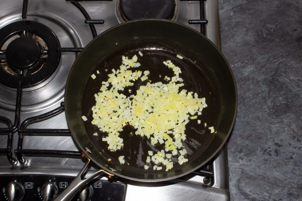 Cooked onion and olive oil in a frying pan on the stove