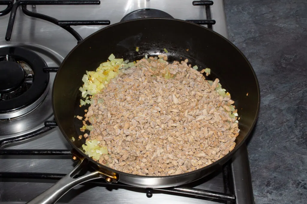 Onion, garlic and frozen soya mince in a frying pan