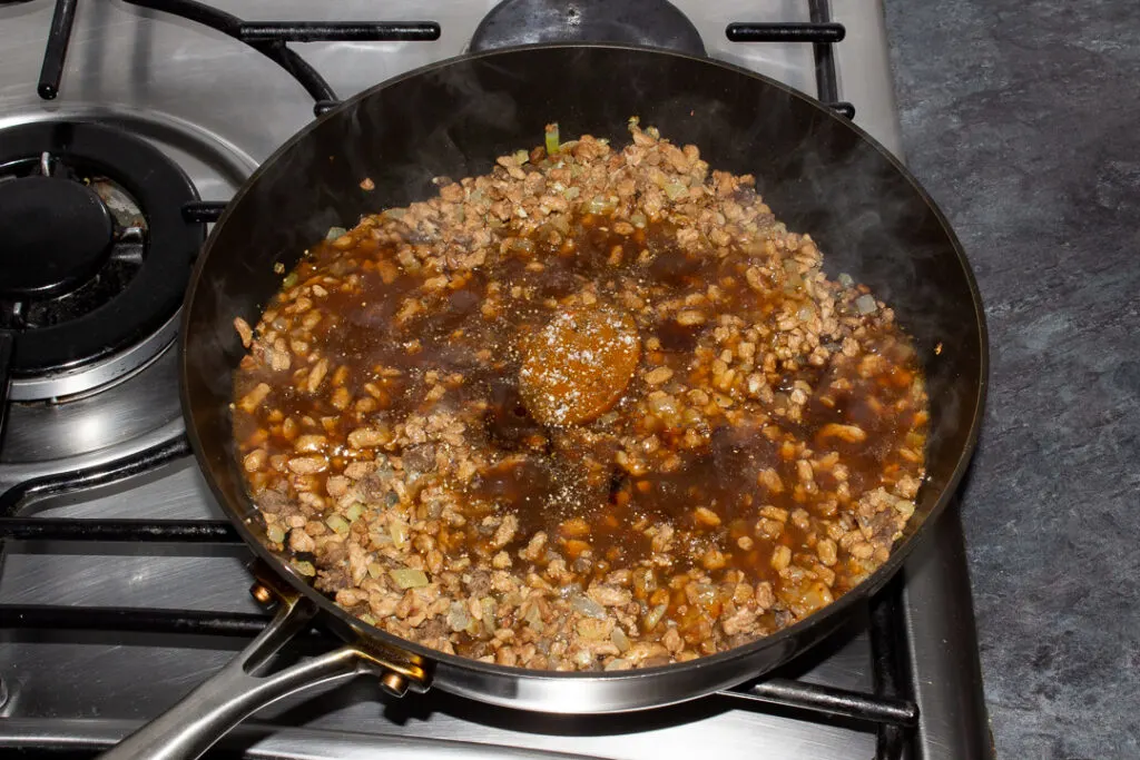 Cooked onion, garlic and soya mince in a frying pan along with onion gravy, a vegetable stock pot, balsamic vinegar and salt and pepper.