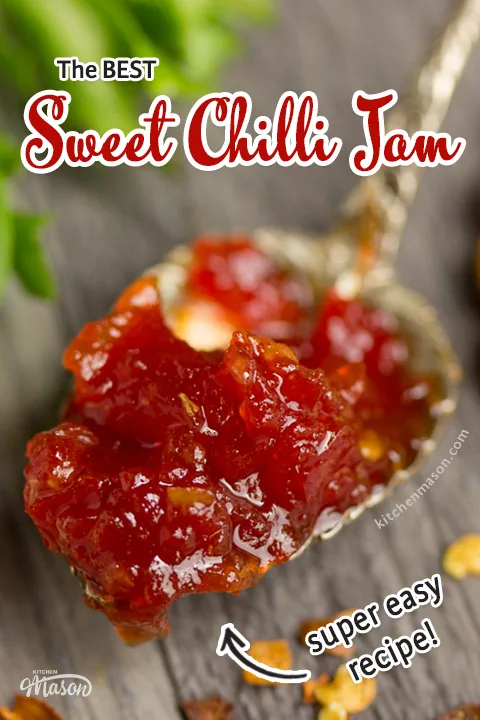 A close up of sweet chilli jam on a gold spoon set on a grey wooden backdrop with lettuce and chilli flakes in the background.