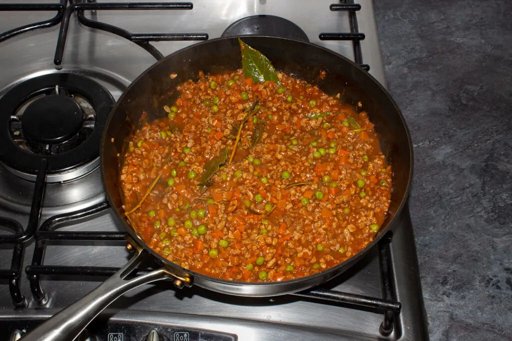 Thickened vegetarian shepherd's pie mince ingredients together in a frying pan on the hob after being cooked