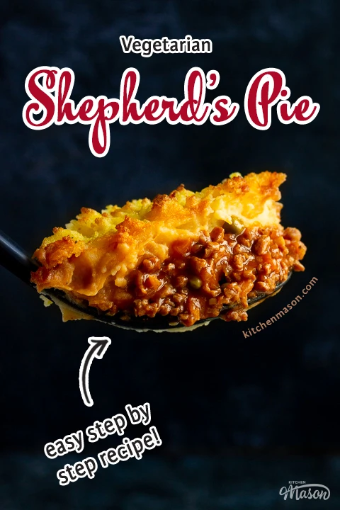 A close up of a large spoonful of vegetarian shepherd's pie up against a deep blue backdrop