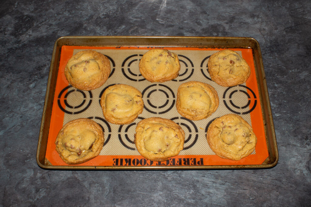 Baked Creme Egg cookies on a lined baking tray
